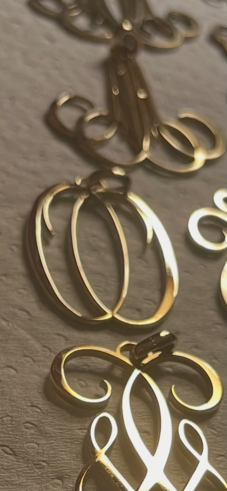 Détail de lettres monogrammées dorées, travail de dessin de l'atelier